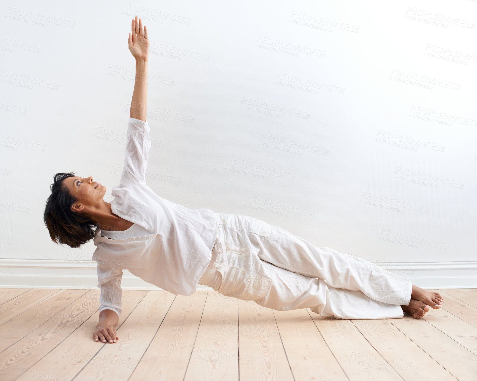 Buy stock photo A fit young woman performing the side plank pose during her yoga routine