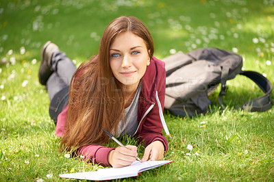 Buy stock photo Woman, student and grass for writing, portrait or planning at university, campus or park for studying. Girl, book and pen for education, learning or brainstorming ideas on lawn at college in sunshine