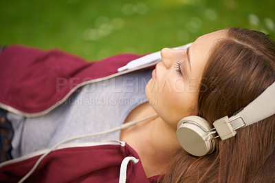 Buy stock photo Woman, student and headphones for music on grass to relax, summer and audio streaming subscription. Girl, campus lawn and park with meditation sound, sleep and peace for listening, radio and podcast