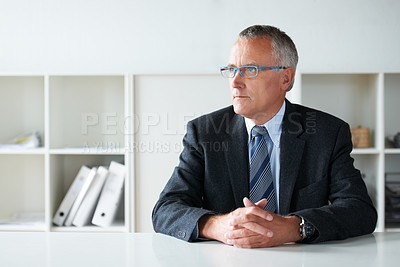 Buy stock photo Shot of a senior businessman sitting at a table