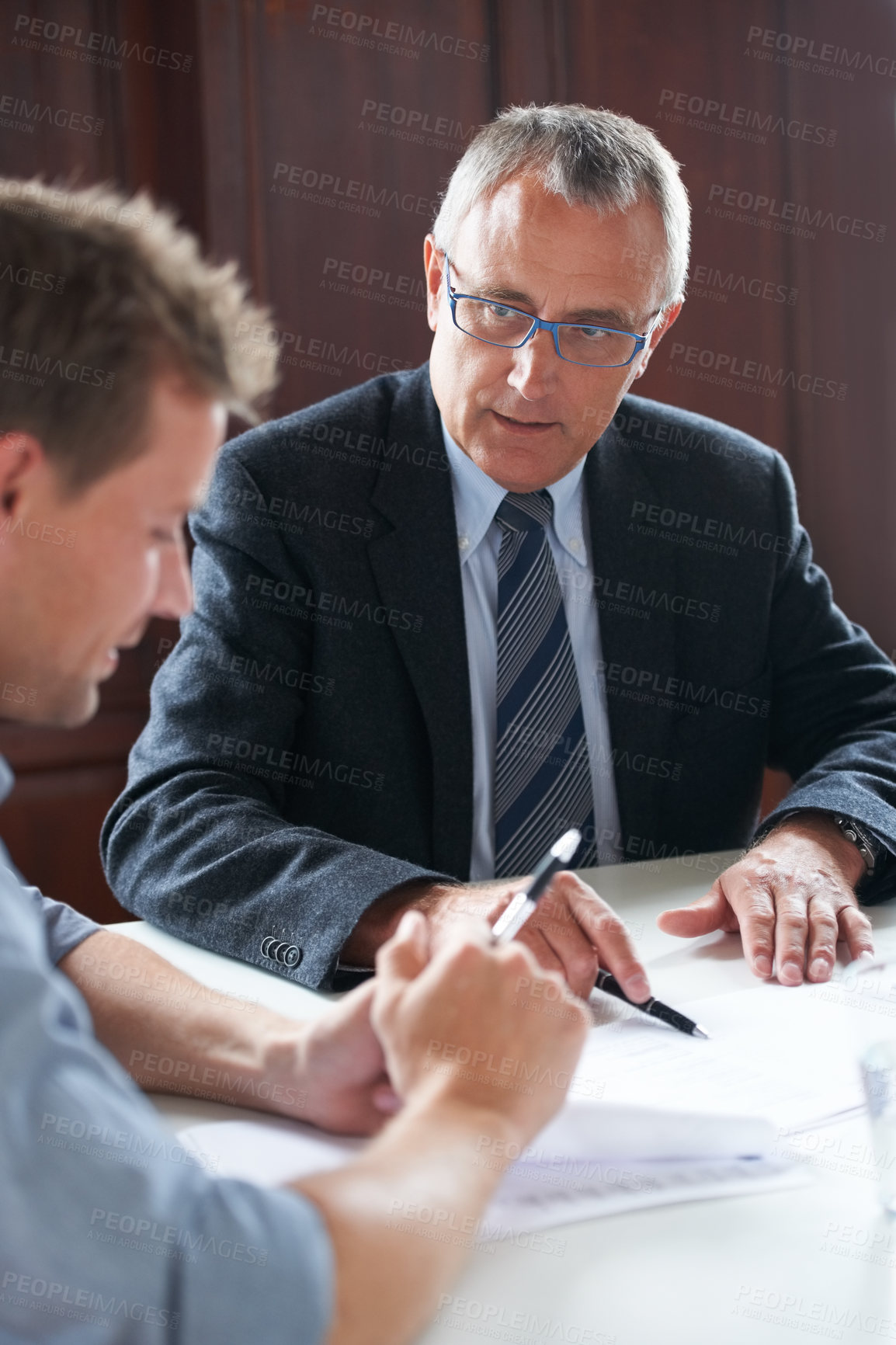 Buy stock photo Shot of two colleagues discussing paperwork together 