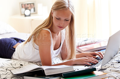 Buy stock photo Young college student working on an assignment at home