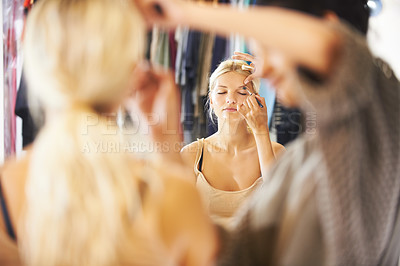 Buy stock photo Pretty young woman having her makeup applied by a stylist