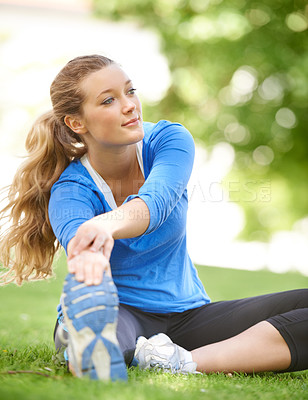 Buy stock photo Attractive young runner stretching before a run