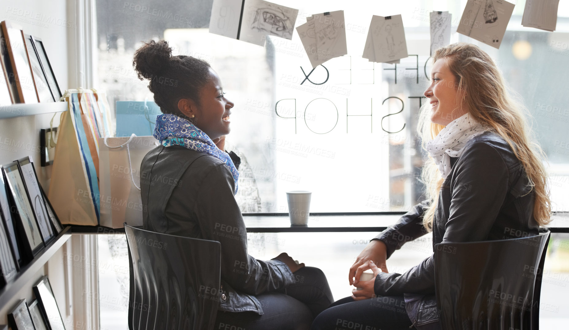 Buy stock photo Two young women buying coffee together