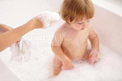 Buy stock photo Cropped shot of a baby girl being bathed by her mother