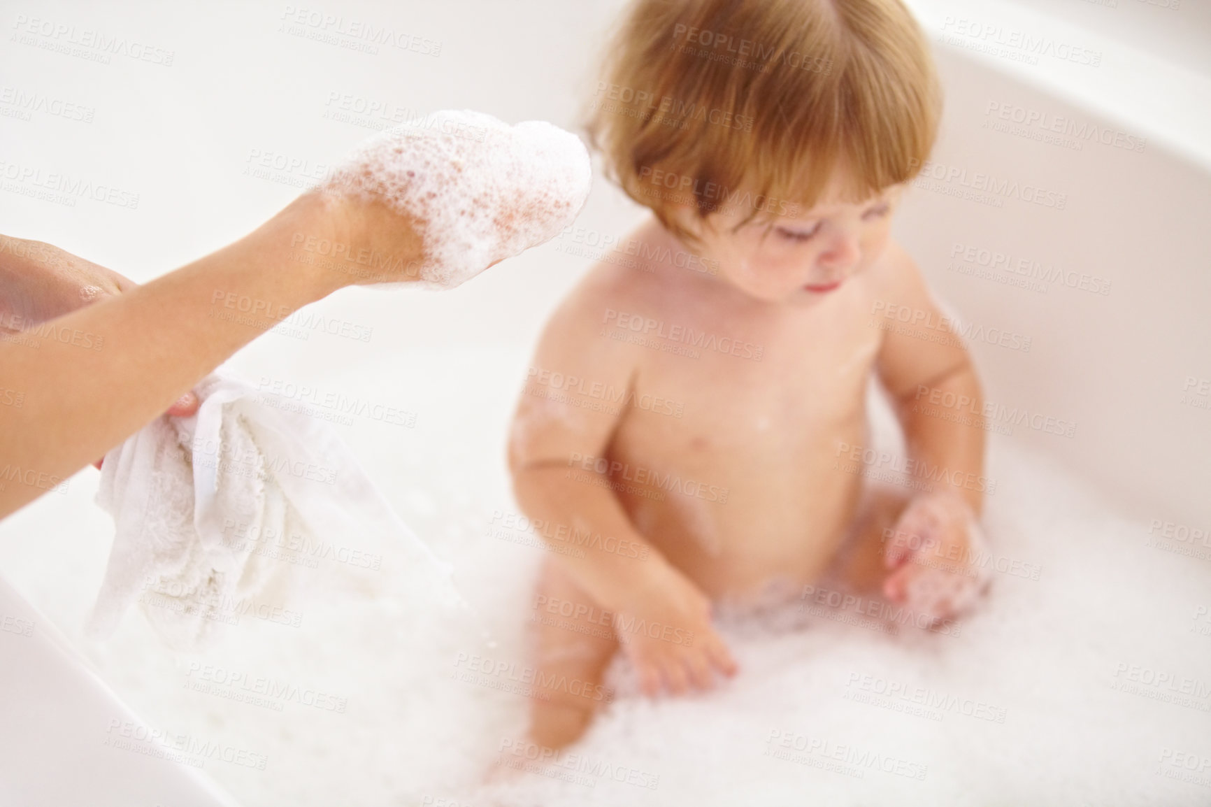 Buy stock photo Cropped shot of a baby girl being bathed by her mother