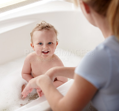 Buy stock photo Cropped shot of a baby boy being bathed by his mother