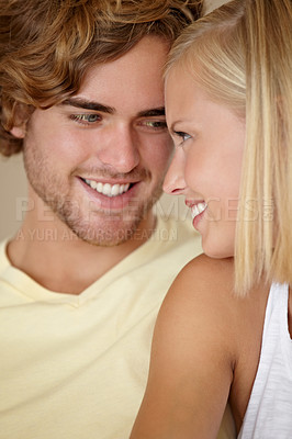 Buy stock photo Face, love and smile with a young couple closeup in their home together for romance or bonding. Relax, happy or dating with a man and woman in their apartment to relax during a weekend break