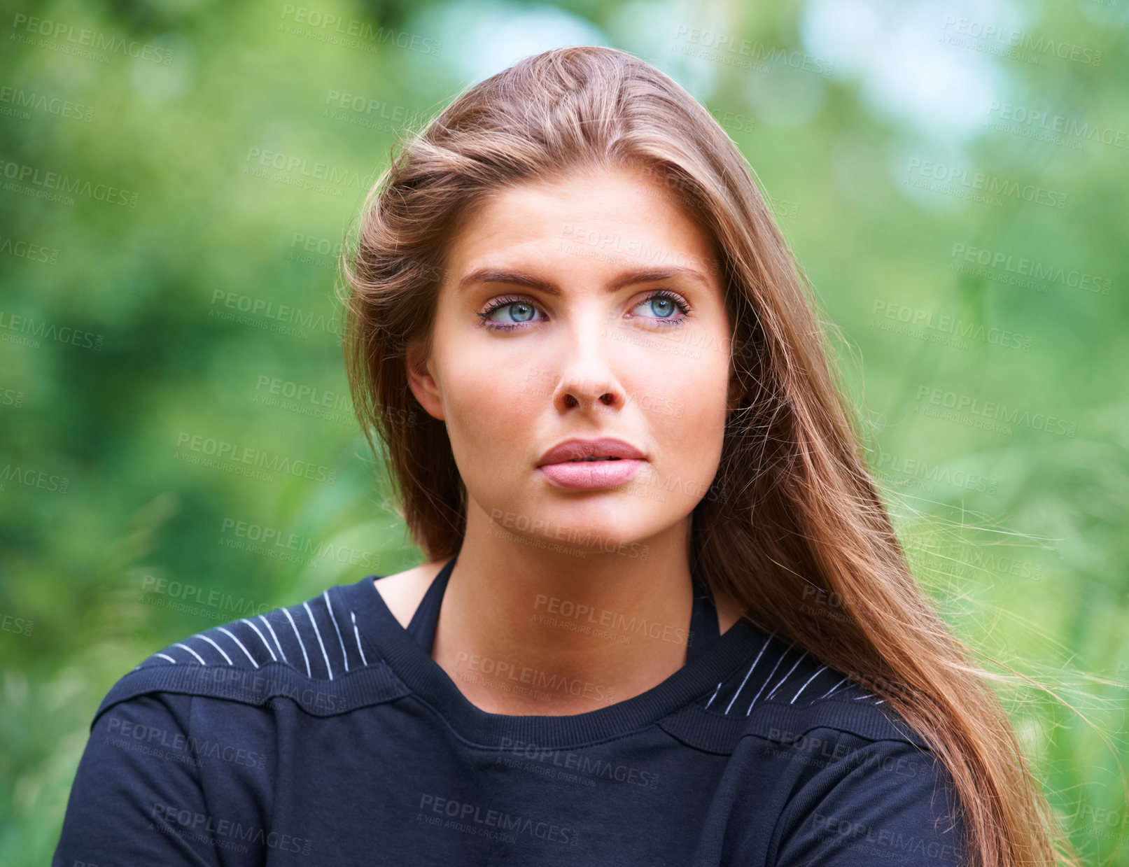Buy stock photo A gorgeous young woman looking away thoughtfully outdoors