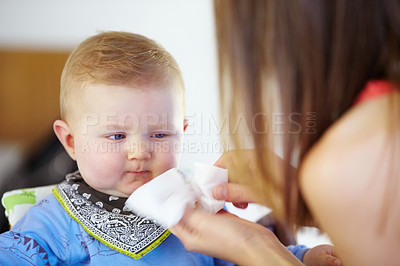 Buy stock photo Woman, baby and wipe of mouth for eating, delicious and food for breakfast in kitchen. Little boy, toddler and looking at mother for clean up of yummy, meal or snack for hunger with napkin for mess