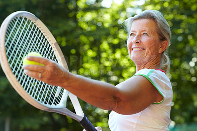 Buy stock photo Senior woman preparing to serve a tennis ball