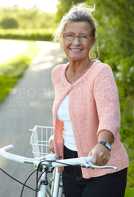 Buy stock photo Portrait, smile and senior woman on bike outdoor, exercise and fitness in summer. Happy, elderly person on bicycle in nature or garden for cycling in countryside for body health, travel and glasses