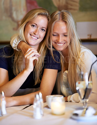 Buy stock photo Shot of two young friends spending time together at a cafe