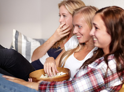Buy stock photo Watching movie, home and friends with popcorn, comedy and funny with humor, snack and bonding together. People, girls and women with cinema, treat and film with weekend break, relax or laughing