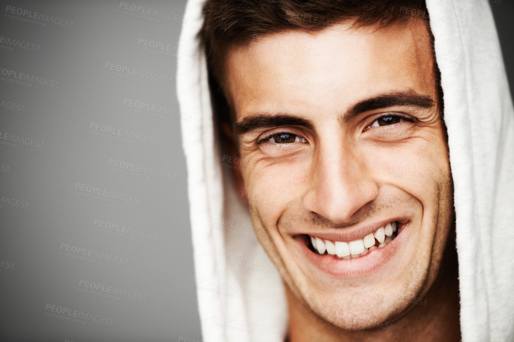 Buy stock photo Portrait, smile and man in hoodie for fashion isolated on a gray studio background mockup space. Happy person, face of model and stylish clothes, casual or cool facial expression in Spain on backdrop