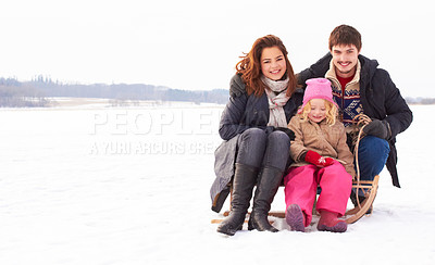 Buy stock photo Two adolescents and a child sitting on a snow sled outdoors on a crisp winter's day