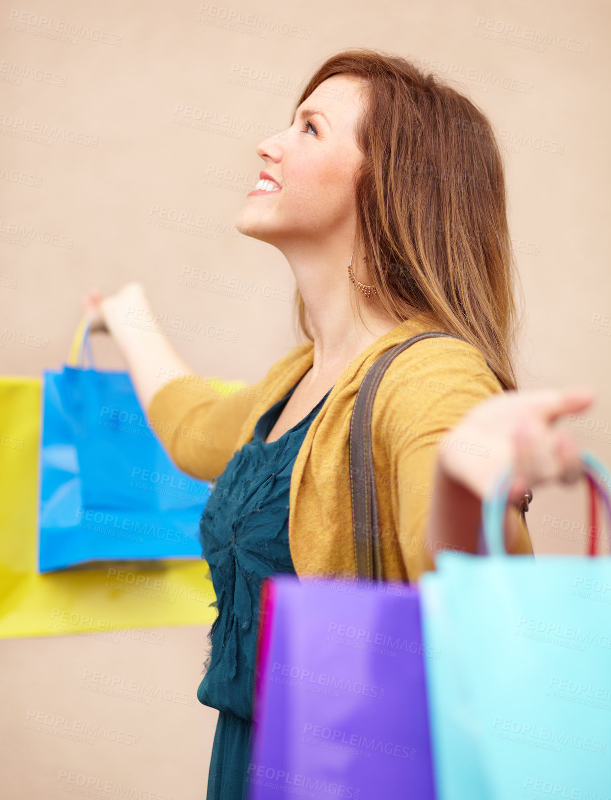 Buy stock photo Cropped shot of an attractive young woman with shopping bags looking upwards