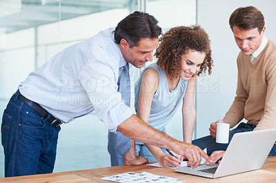 Buy stock photo Business people, laptop and teamwork while talking in an office for collaboration and brainstorming. Men and a woman team together to point at website or online research for a project and planning