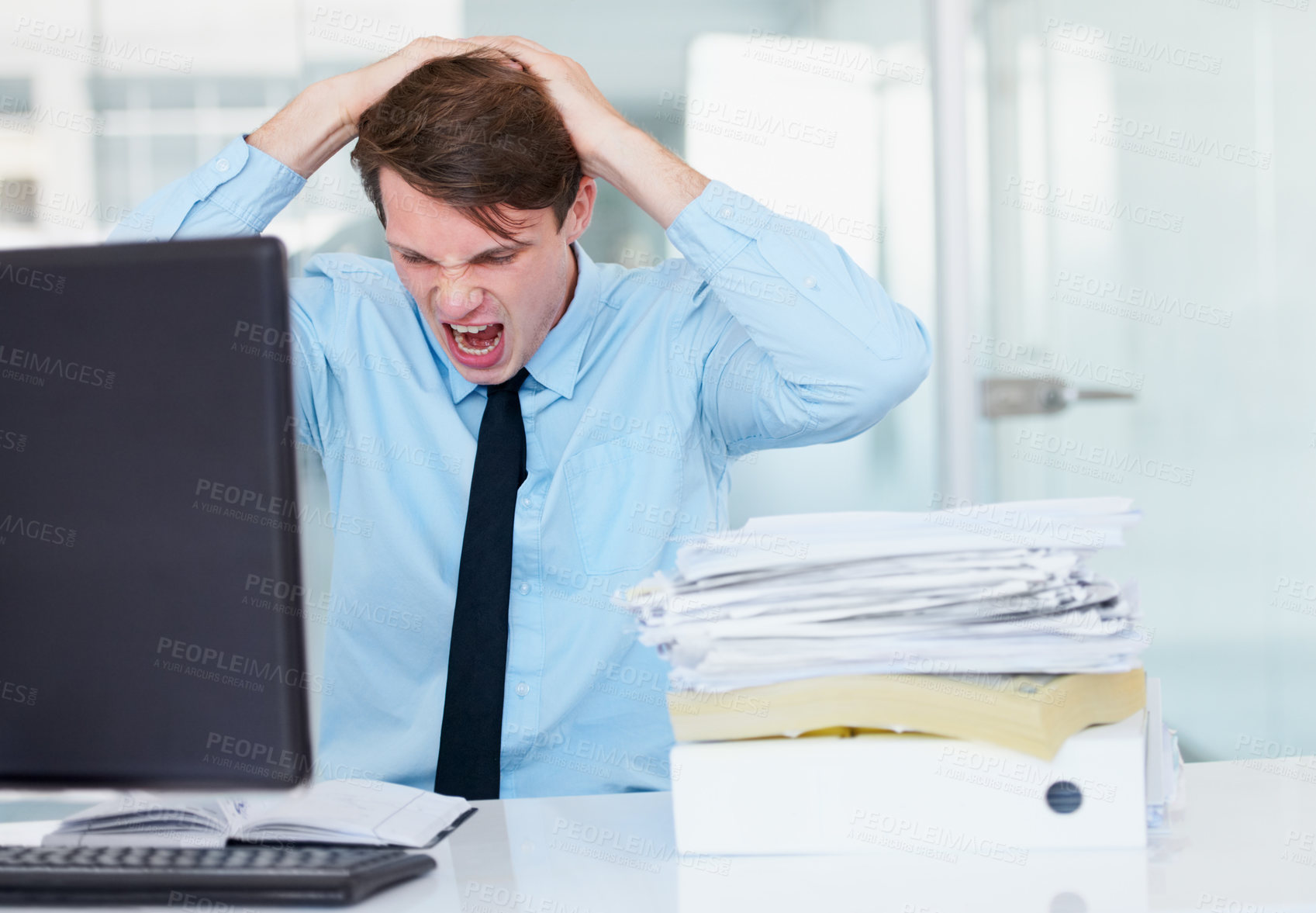 Buy stock photo Stress, shouting and burnout with a business man in his office, sitting at a desk while working on a problem. Audit, tax and anger with a young male employee suffering from deadline pressure at work