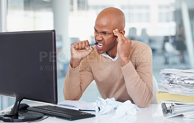 Buy stock photo Stress, computer and burnout with a business man biting his pen at a desk in the office working on a problem. Audit, tax and anger with a frustrated young male employee suffering from anxiety at work