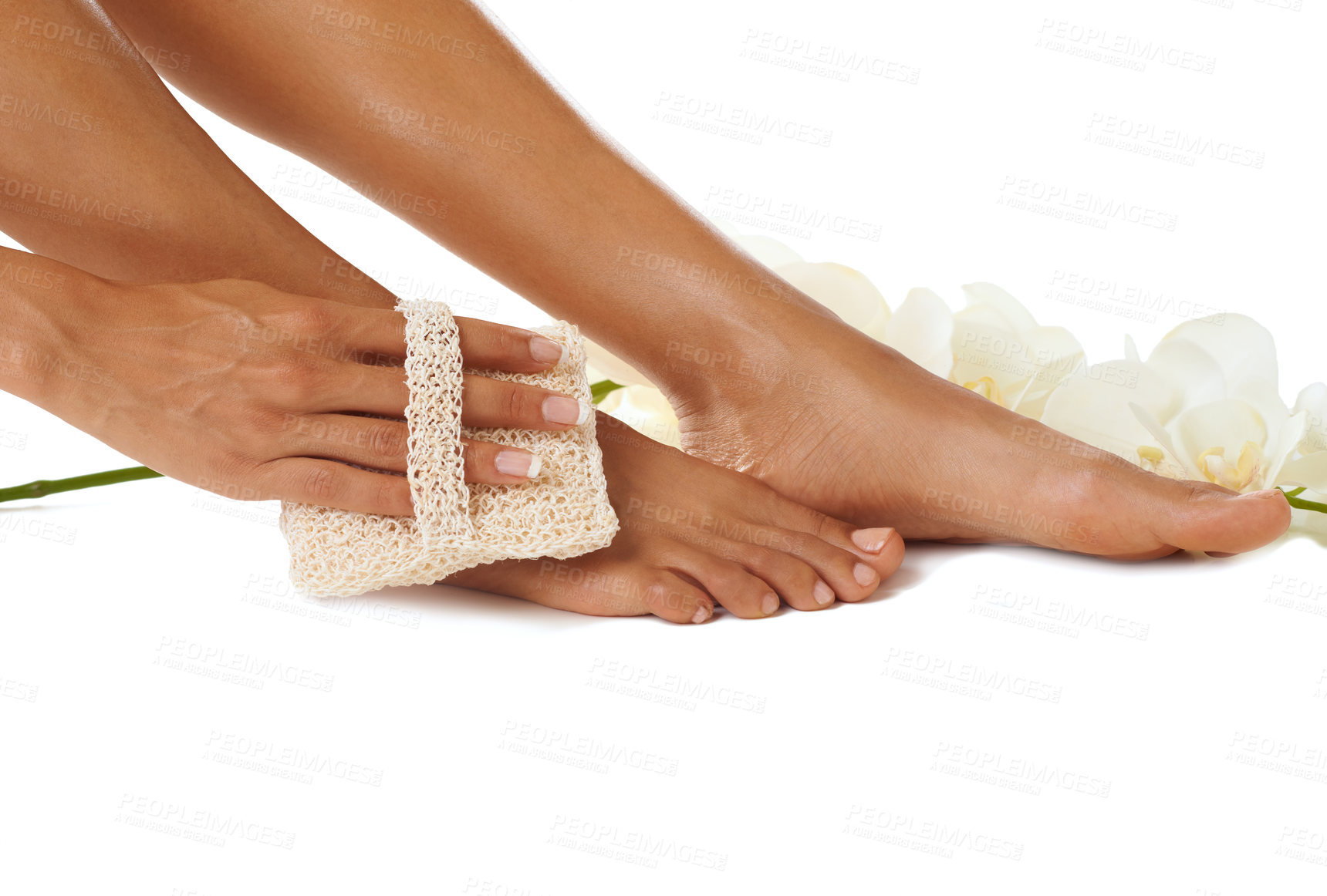 Buy stock photo Feet, skincare and pedicure with a black woman cleaning to exfoliate her skin in studio on a white background. Spa, flowers and hand with a female inside for epilation, body care or wellness