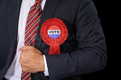 Buy stock photo Cropped view of a man in a suit wearing a voting ribbon ona black background