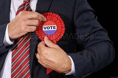 Buy stock photo Man, vote and suit for election, ribbon and politician for support and on dark studio background. Politics, voter choice and representative for party, registration and democracy for voting register 
