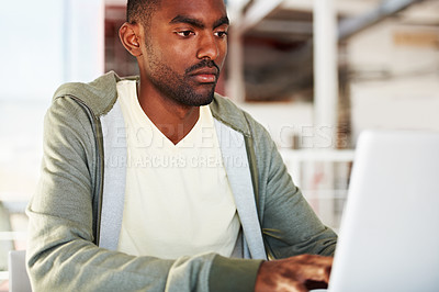 Buy stock photo Serious, laptop and man in office for research, planning or schedule, freelance or analysis. Typing, face and African male manager online with social media, project management or email communication