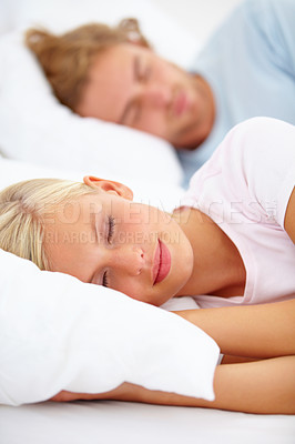Buy stock photo Love, sleep and a couple in a bedroom in the morning to relax in their home together for holiday or vacation. Face, dreaming or eyes closed with a young woman and man in bed in their apartment