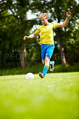 Buy stock photo Sports, man and a soccer player kicking a ball on a field for training, a game or match on a green pitch. Health, fitness or exercise and a young athlete playing football for freedom with energy 