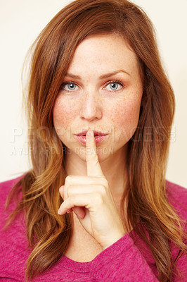 Buy stock photo Portrait of a beautiful young woman with her finger to her lips