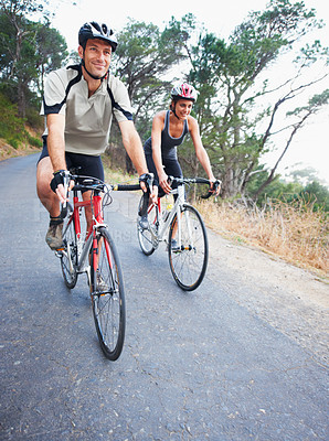 Buy stock photo Happy couple, cycling and road in nature for, fitness, training  or travel on bicycle together. Outdoor, people and exercise on bike for fun, workout and path in countryside for adventure or journey