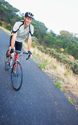 Buy stock photo Shot of a lone rider cycling down a rural road with copy space
