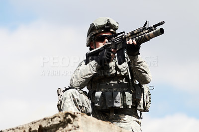 Buy stock photo Low angel view of a sniper crouched down on a roof of a building against a sky background