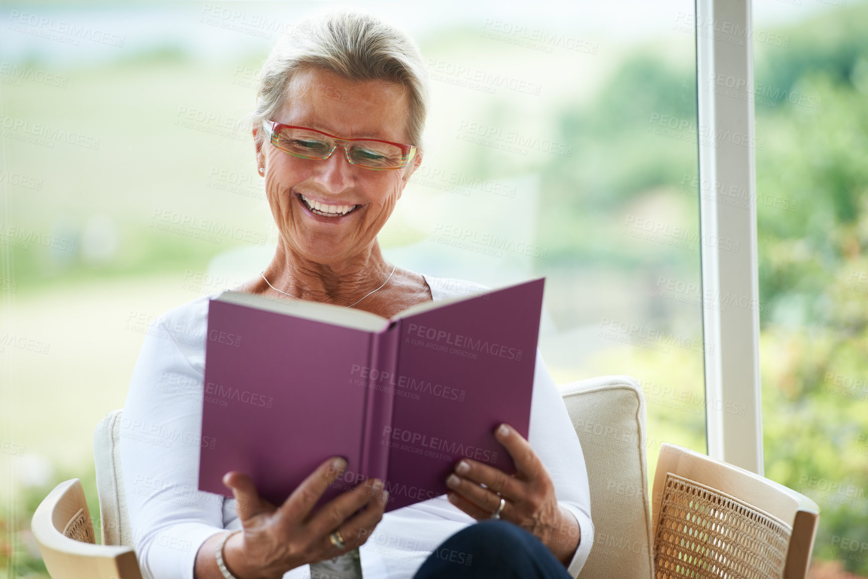 Buy stock photo Senior woman, home and book with reading, chair or relax in living room with smile for story, knowledge or glasses. Happy elderly lady, person and thinking in lounge in retirement with novel in house