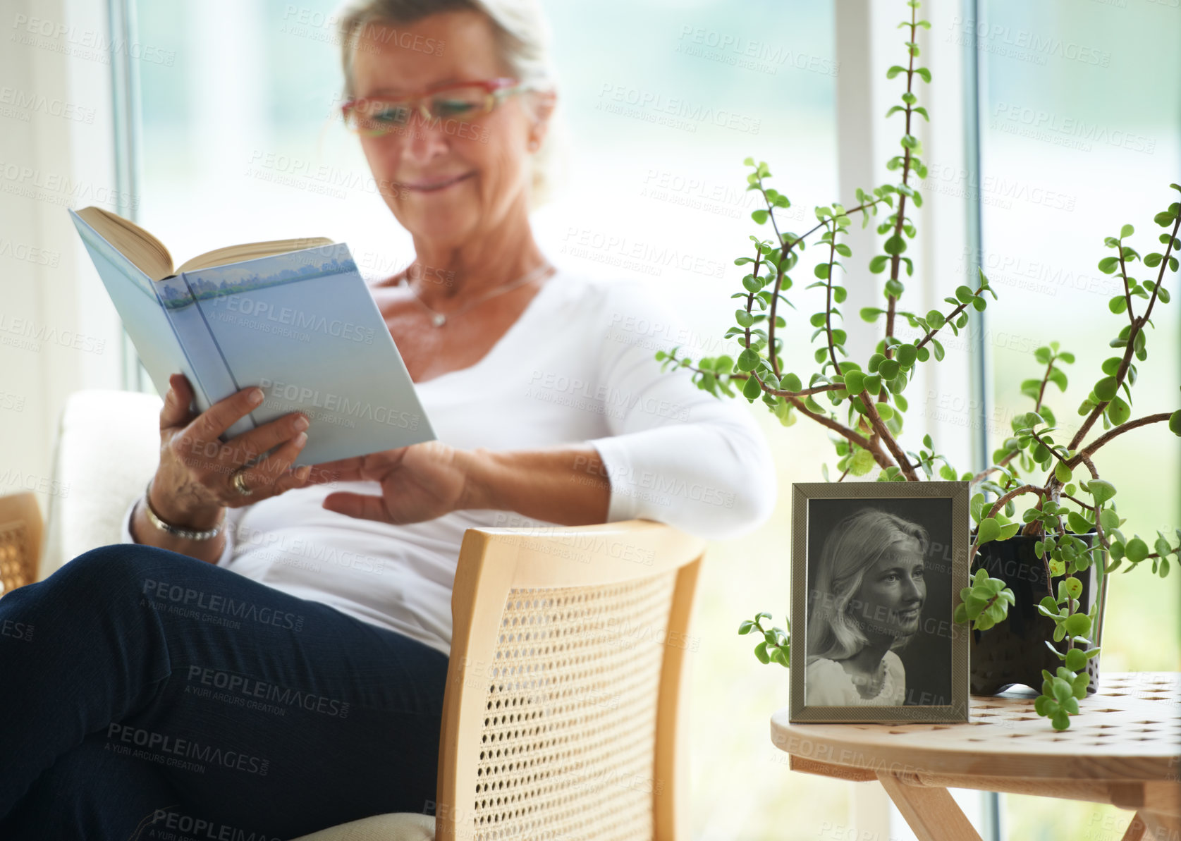 Buy stock photo Senior, woman and relaxing with book in home for reading, wellness or self care. Elderly person, glasses and smile with happiness for resting, peace or retirement with vintage photograph for memory