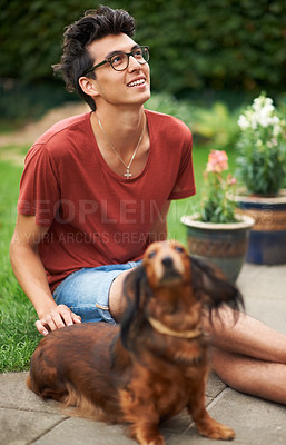 Buy stock photo Young guy hanging out with his dog outdoors