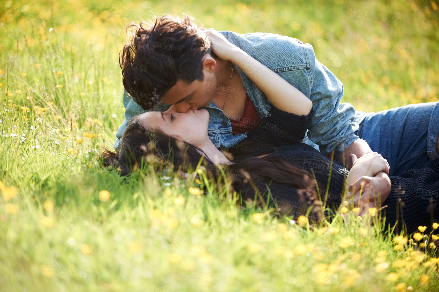 Buy stock photo Love, kiss and peace with couple in grass of field for summer, date and valentines day bonding. Affectionate, romance and nature with man and woman lying in garden meadow for spring, relax and happy