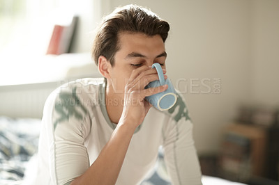 Buy stock photo Relax, morning and a man drinking coffee in the bedroom of his home to relax or wake up on the weekend. Tea, caffeine or beverage with a young person on his bed in an apartment to enjoy a beverage