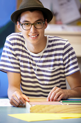 Buy stock photo Young teacher's aid sitting at a desk in front of some stationery