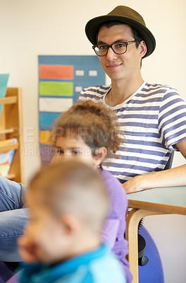 Buy stock photo Kindergarten, teacher and happy man in class with kids or thinking about montessori, education and learning. Children, school and teaching volunteer sitting in classroom with inspiration and ideas