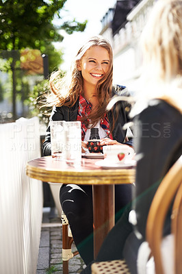 Buy stock photo Two young girlfriends meeting at a cafe for coffee and a chat