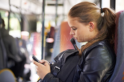 Buy stock photo Student, phone and transport to school on bus with a backpack and typing on social media. Teenager, girl and journey on public transportation or travel to college, campus or university with cellphone