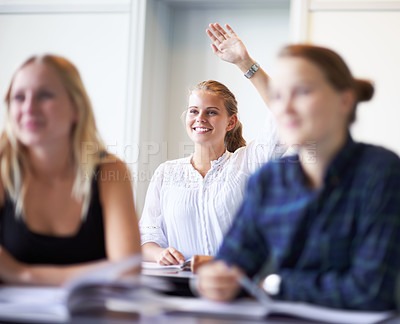 Buy stock photo A teenage girl putting up her hand in class