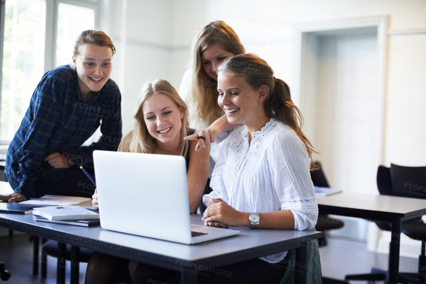Buy stock photo A group of teenage girls working on a laptop in the classroom