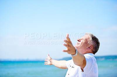 Buy stock photo A senior man with his arms freely raised on the beach
