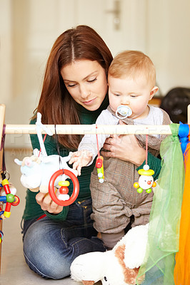 Buy stock photo Mother, baby and playing with toys in living room for childhood development in home. Woman, son and hold with pacifier for care, love and support in bonding, together and future growth with games