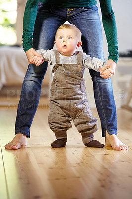 Buy stock photo Mother, baby and helping with walking in home with support, trust and care for childhood development. Toddler, little boy and holding hand for motor skills, assistance and mobility in living room