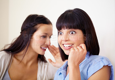 Buy stock photo A young woman looking shocked and entertained as she hears a secret